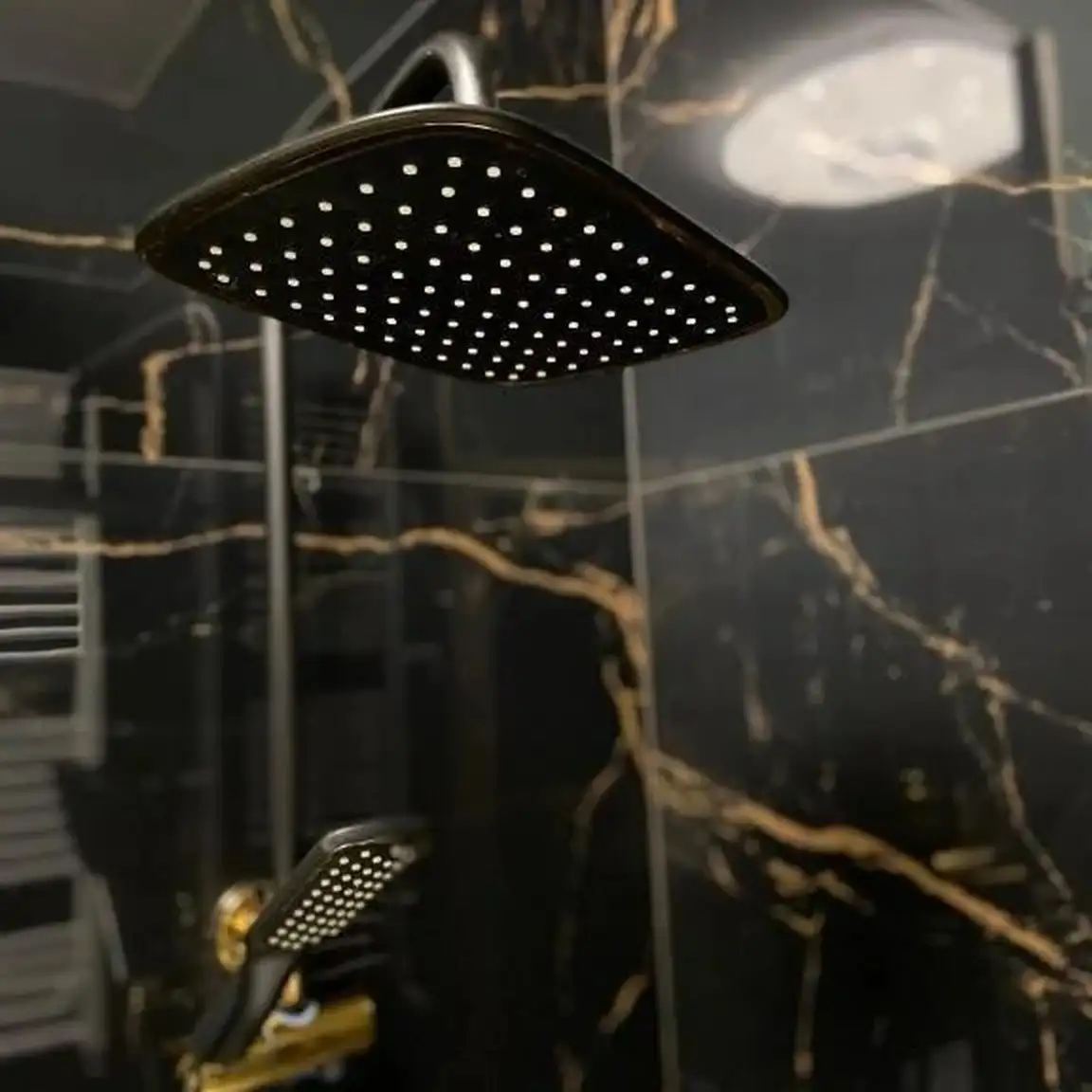 Dusche in schwarzer Marmoroptik mit Regenbrause