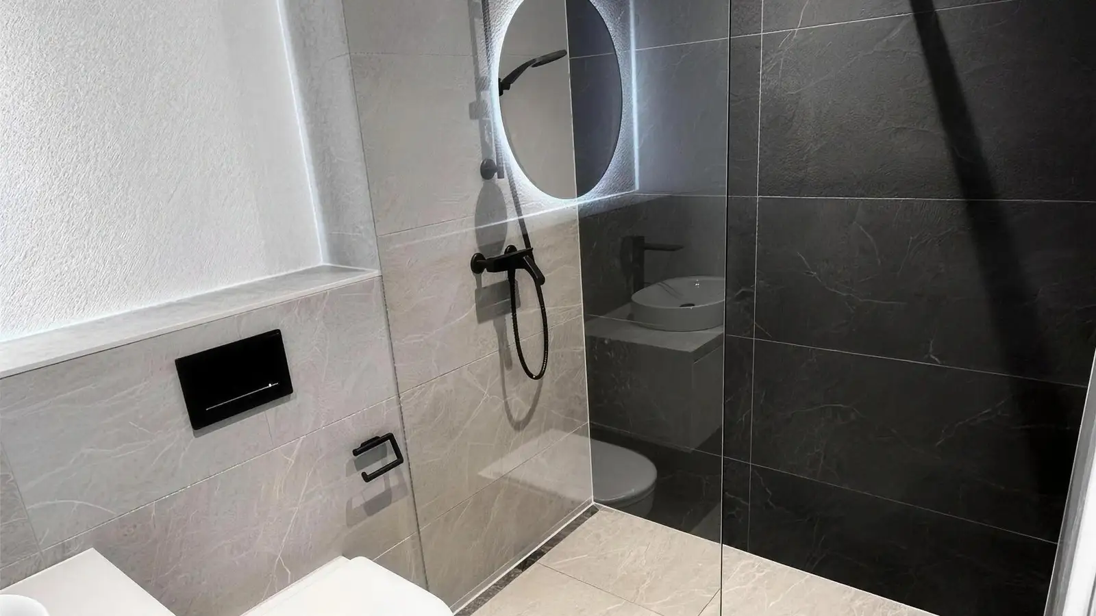 Bad in Grau mit Grossformatplatten und Walk-in-Dusche