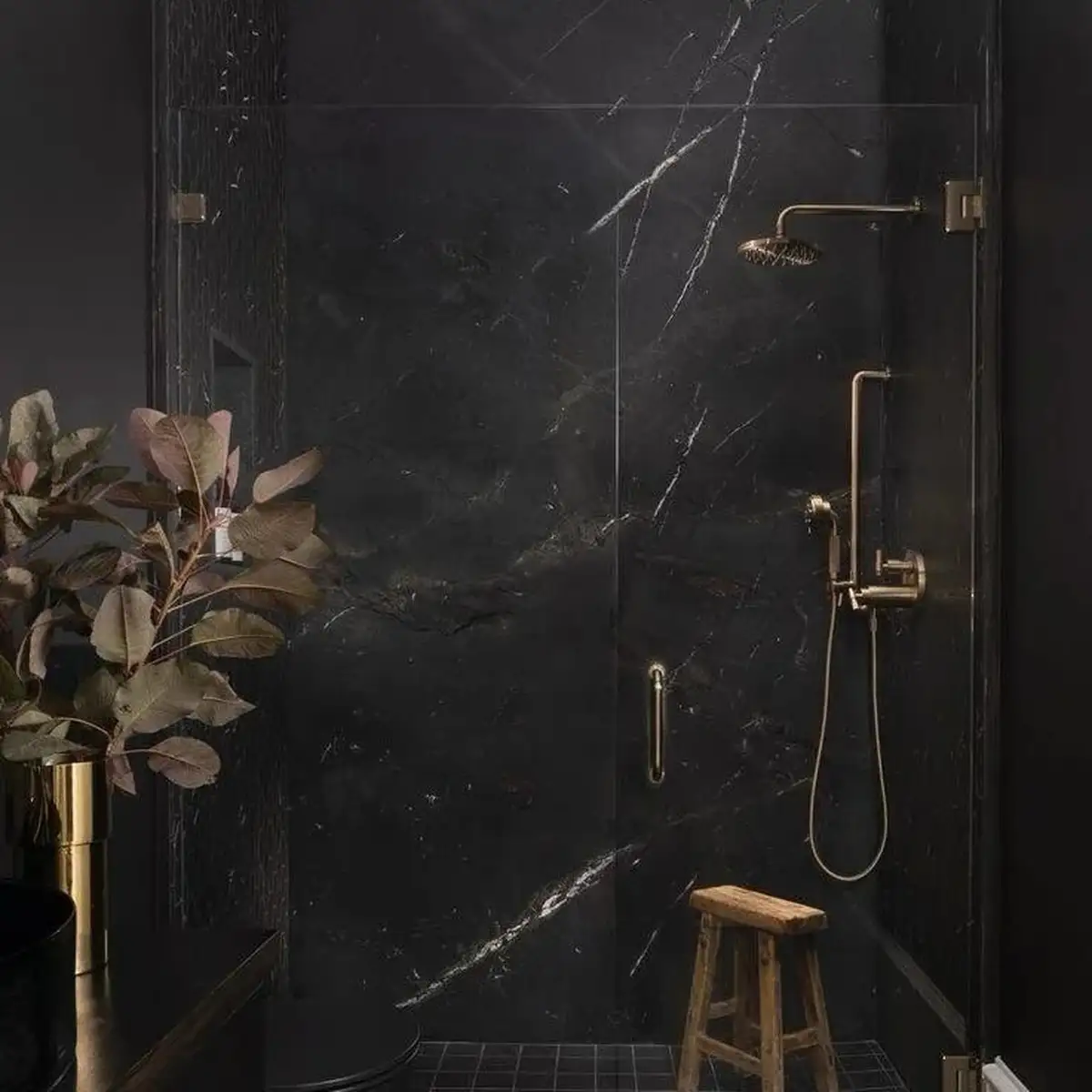 Dusche in schwarzer Marmoroptik mit Messingarmatur