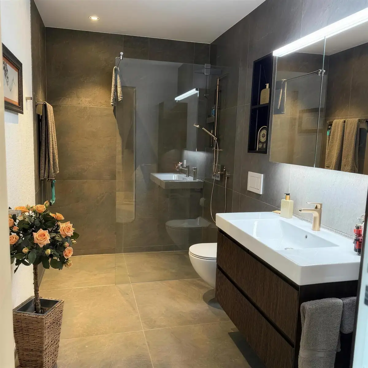 Bad in Erdtönen mit Dusche und Waschtisch