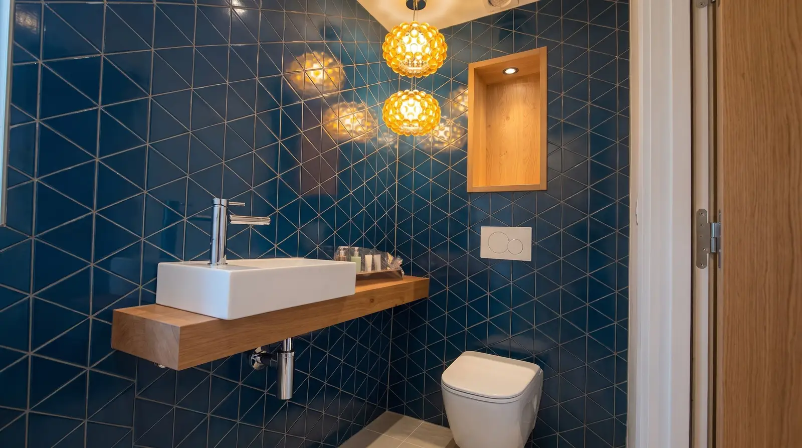 Gäste-WC mit blauen Dreieckplatten und Holzablage