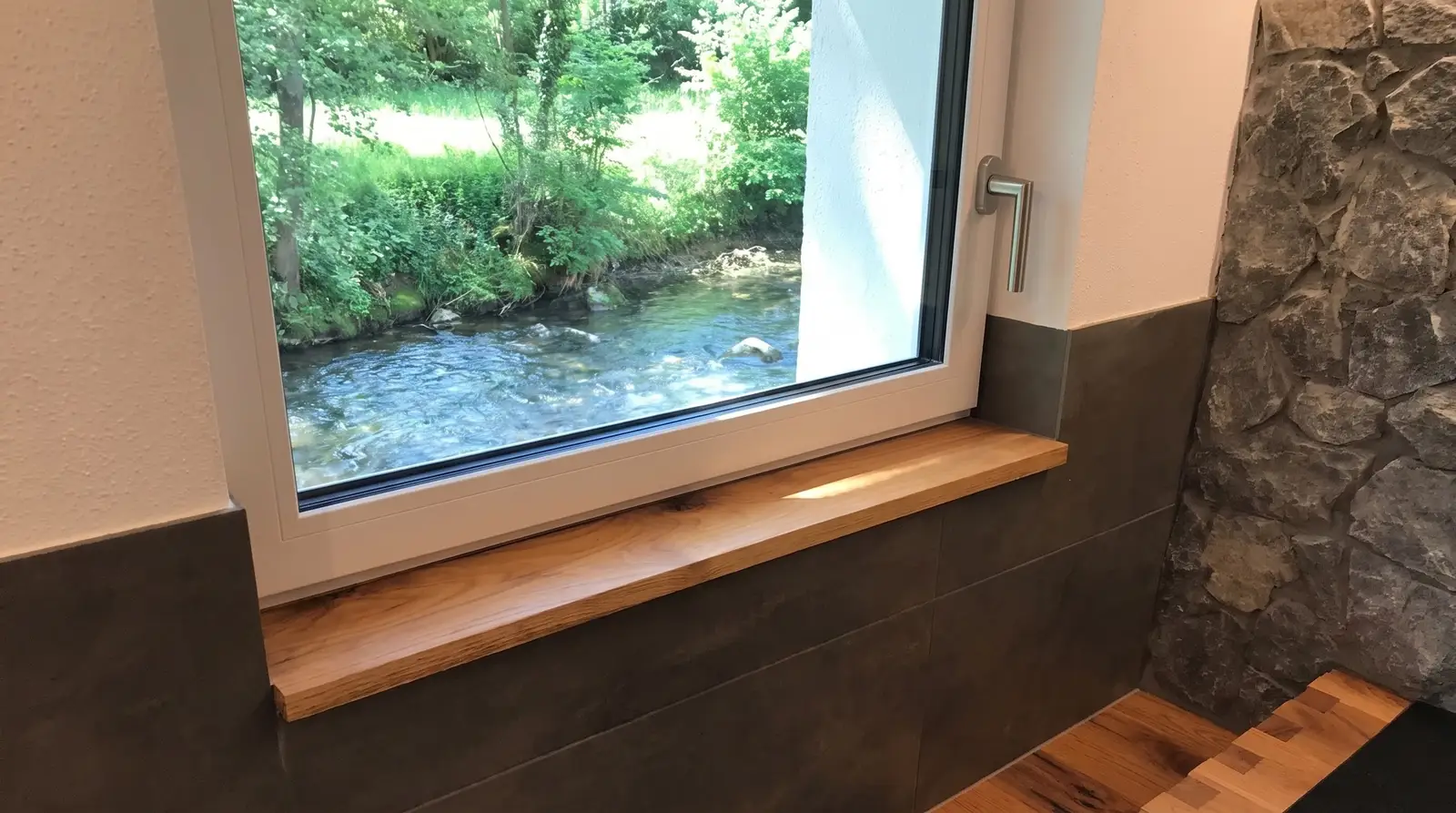 Bad mit Naturstein, Holzfenster und Sitzbank