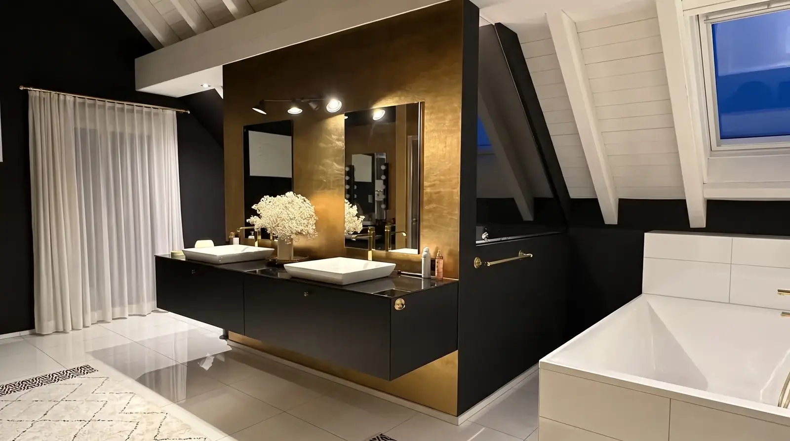 Bad mit goldener Wand, schwarzem Doppelwaschtisch und Spiegeln